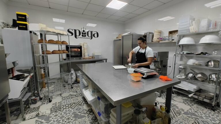 Interior del obrador artesanal Spiga durante la jornada de trabajo — mesa central, balanza y estantería con masas